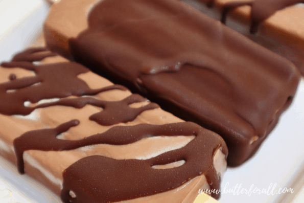 Chocolate-dipped frosty fudgesicles on a plate.