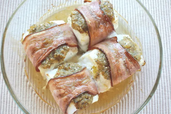 Four cooked pieces of bacon-wrapped halibut.