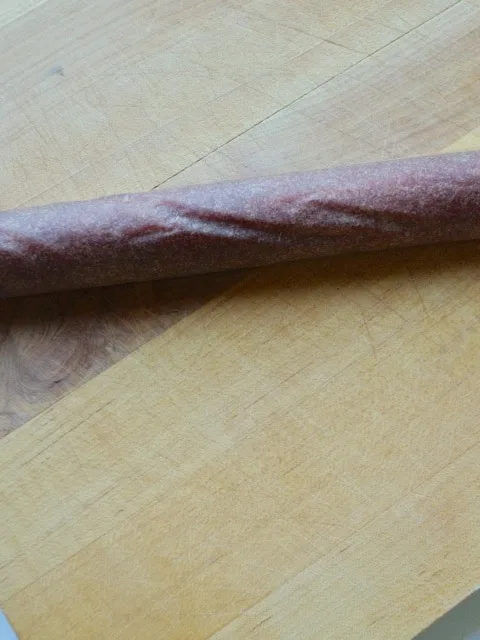 Yellow plum fruit leather rolled up into a spiral tube for cutting.