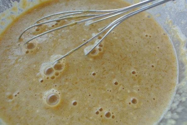 Clafoutis batter in a bowl with a whisk. 