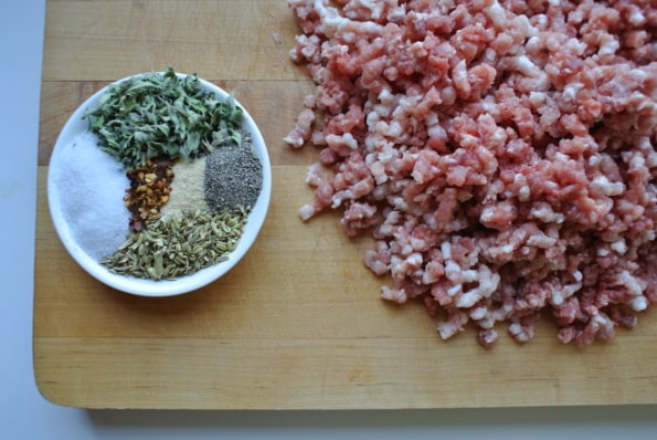 Ground pork with a dish of seasoning.