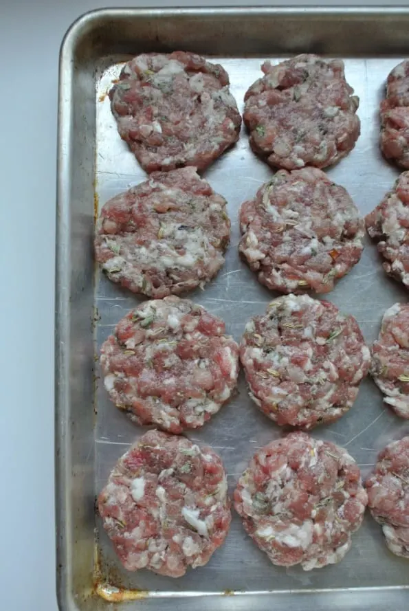 Sausage patties in a pan ready to cook.
