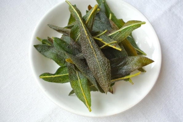 Sage leaves fried in pork drippings on a plate.