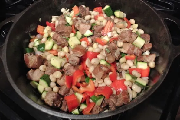 Cooked pork and fresh shelling beans combined in a pan.