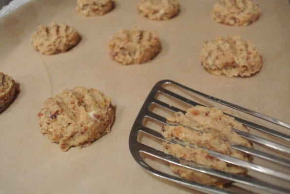 okie dough scoops being flattened with a spatula.