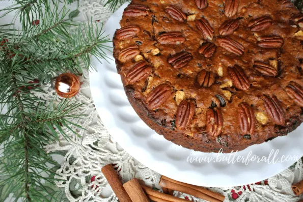 A baked fruit and nut cake with Christmas decor.