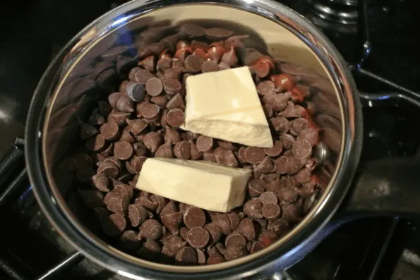 A bowl of chocolate chips and butter ready to melt.