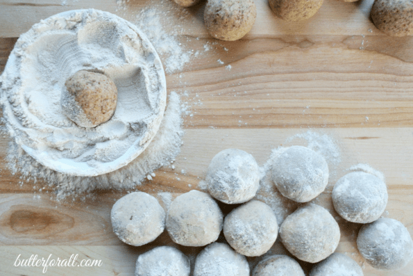 Snowball cookies being rolled in maple sugar.