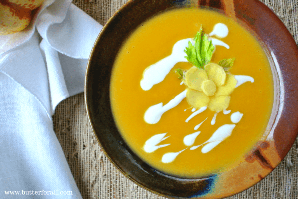 A bowl of winter squash and ginger soup with sour cream garnish.