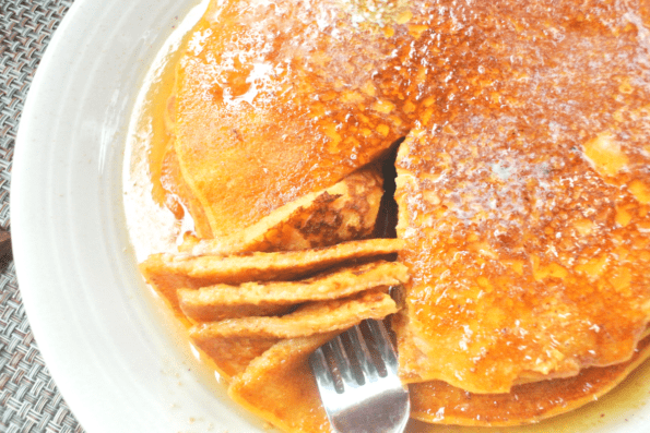 A stack of sweet potato sourdough pancakes on a plate.