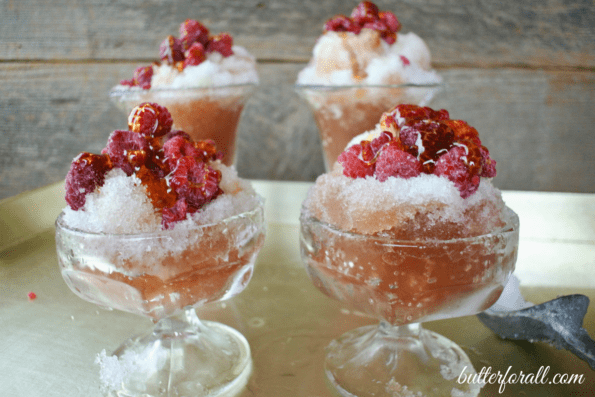 Four bowls of fresh snow with honey and berries.