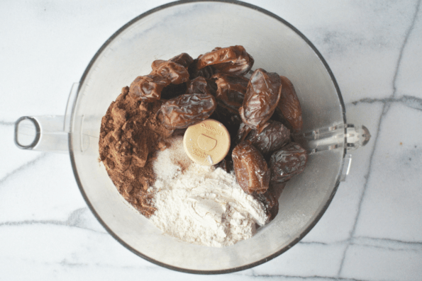 Dates and dry ingredients in a food processor bowl.