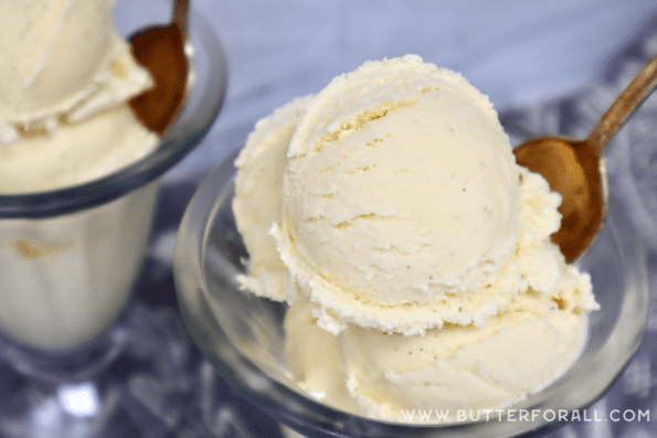 Specks of vanilla bean show in scoops of cream colored ice cream.