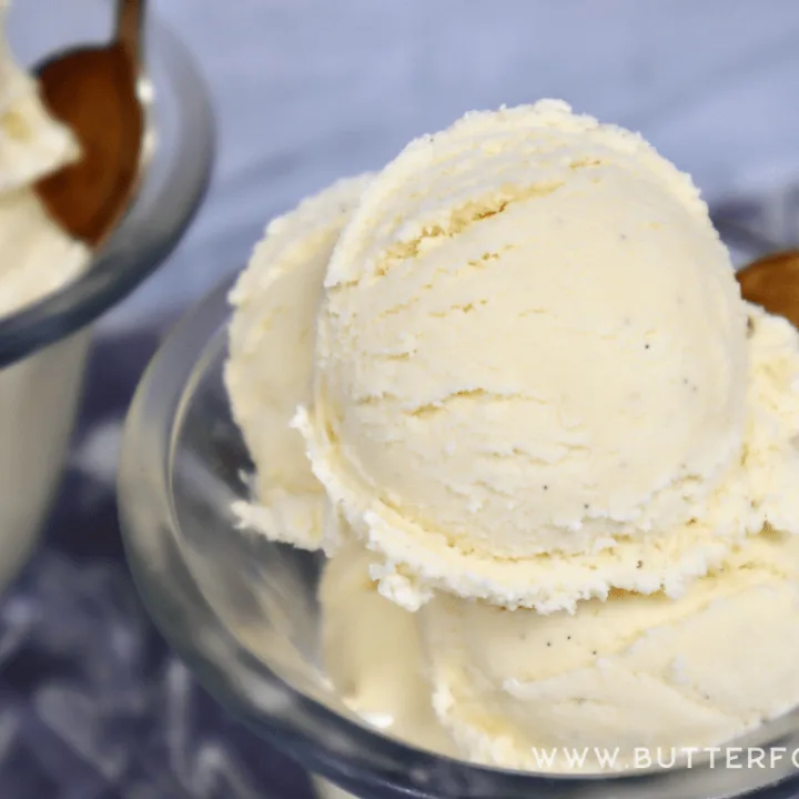 Specks of vanilla bean show in scoops of cream colored ice cream.