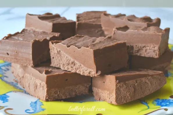 A stack of chocolate coconut butter fudge cut into squares.