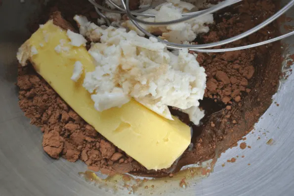 Chocolate coconut butter fudge ingredients in a bowl with a whisk.