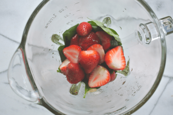 Fresh strawberries in a glass measuring cup.