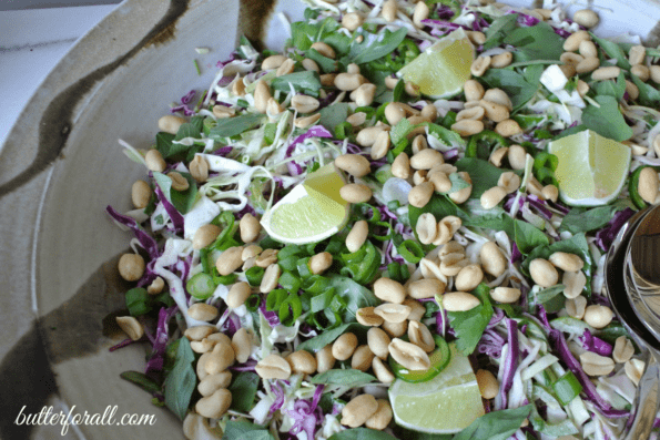 A close-up of a bowl of Thai basil and roasted peanut slaw.