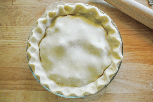 The unbaked pie with finished crimped crust edges.