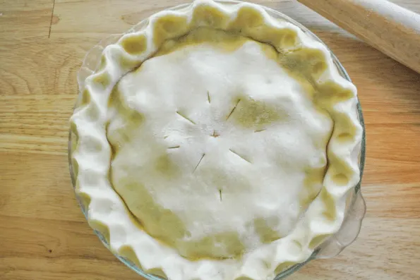 The unbaked pie with vents cut into the top.