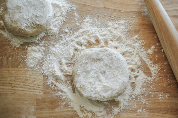 Two floured and flattened balls of pie dough.