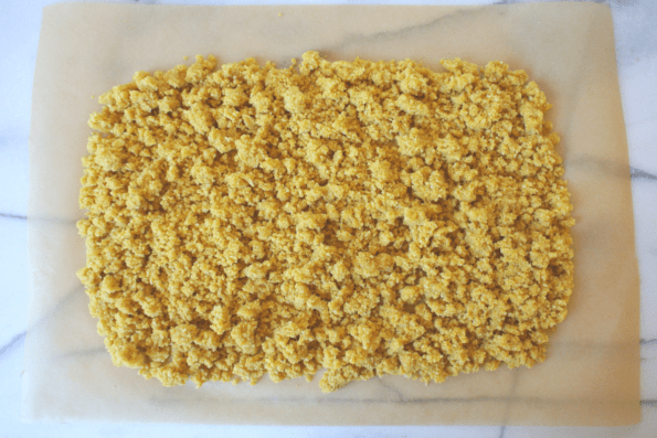 Cracker dough spread onto parchment.