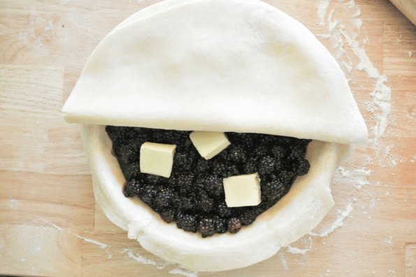 The top crust being put on the pie.