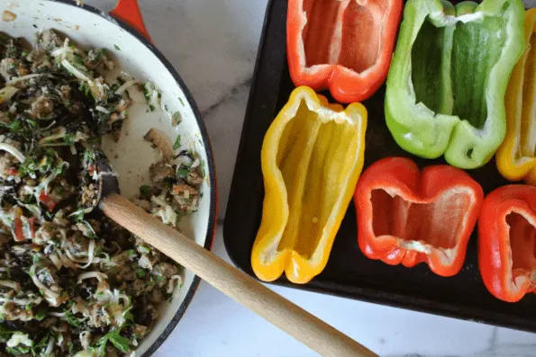 A tray of raw, cut bell peppers with a bowl of filling.