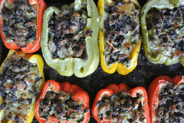 Baked stuffed bell peppers showing the melted cheesy top.