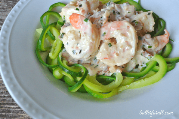 A plate of creamy bacon and shrimp Alfredo with zucchini noodles.