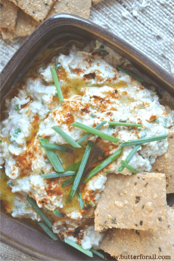 A dish of fire roasted eggplant baba ganoush with crackers.