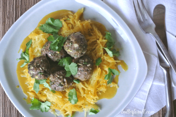 A plate of spicy lamb meatballs on top of spaghetti squash.