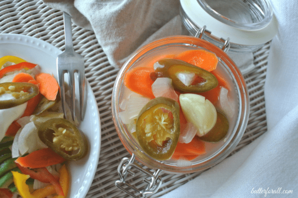 A jar of escabeche next to some on a plate.
