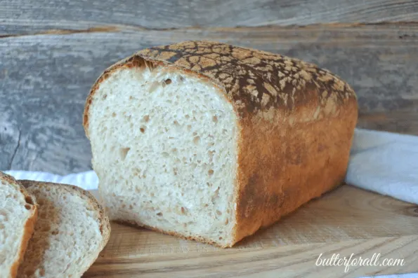 A loaf of butter top sourdough sliced to show the crumb.