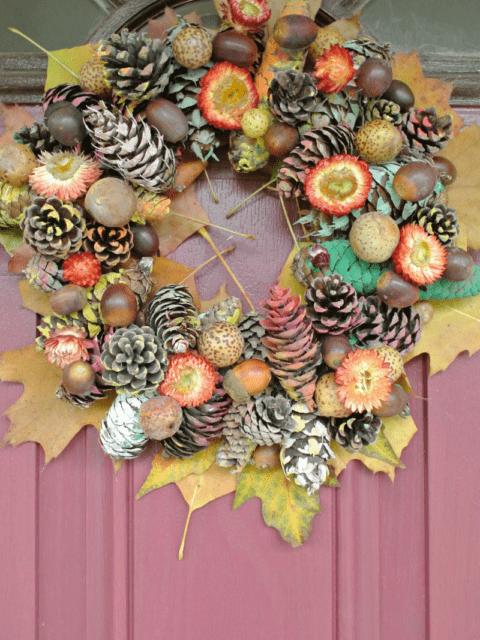 A fall wreath with leaves and pinecones.