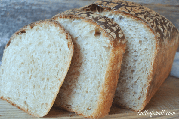 A loaf of butter top sourdough sliced to show the crumb.