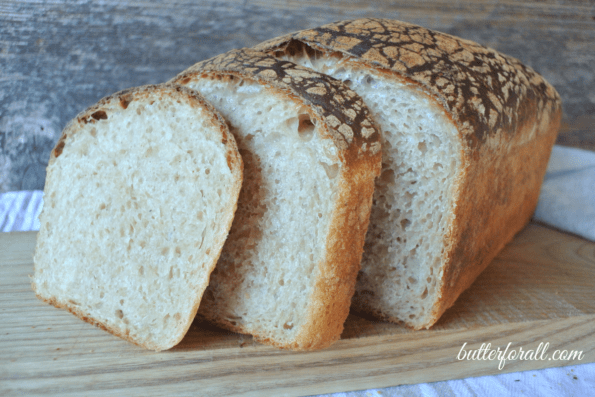 A loaf of butter top sourdough sliced to show the crumb.