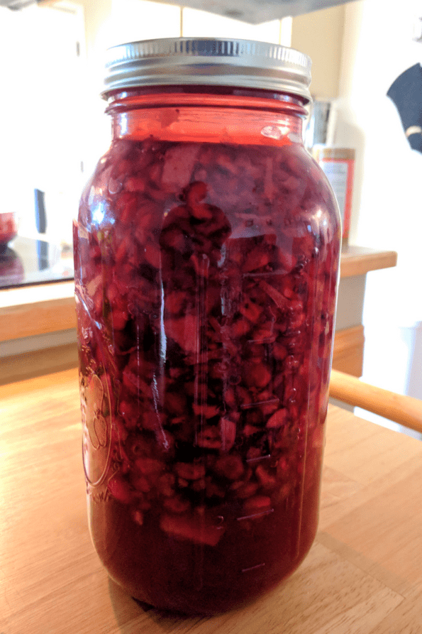 A close-up of a jar of fermenting cranberries.