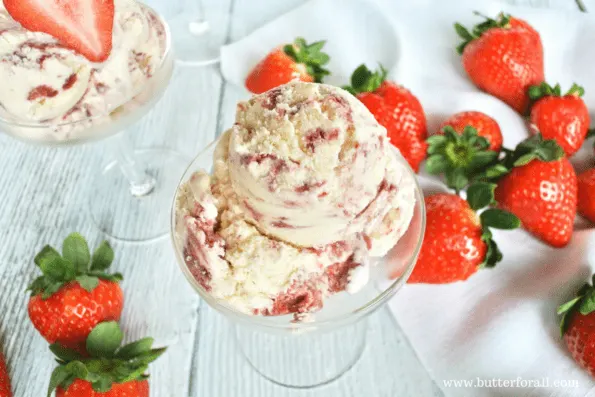 A dish of real strawberry cheesecake ice cream with strawberries.