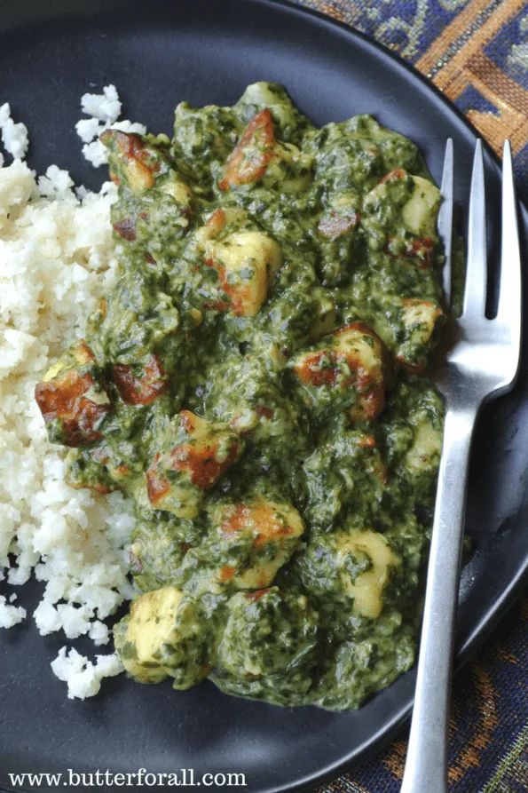 A close-up of a plate of saag paneer with cauliflower rice.