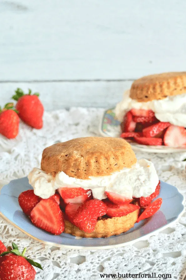 Plates of sourdough shortcakes stuffed with strawberries and whipped cream.
