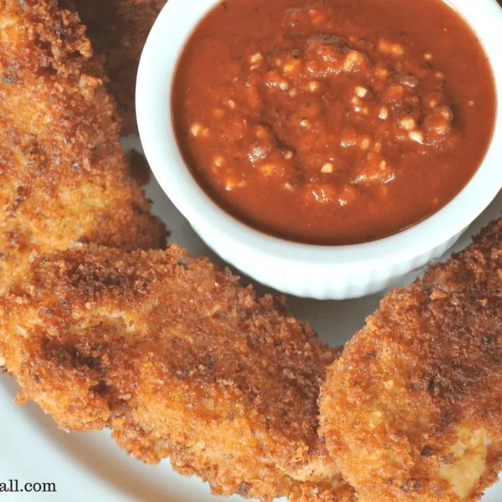 Freshly fired, golden brown and crispy Parmesan and sourdough crusted chicken strips.