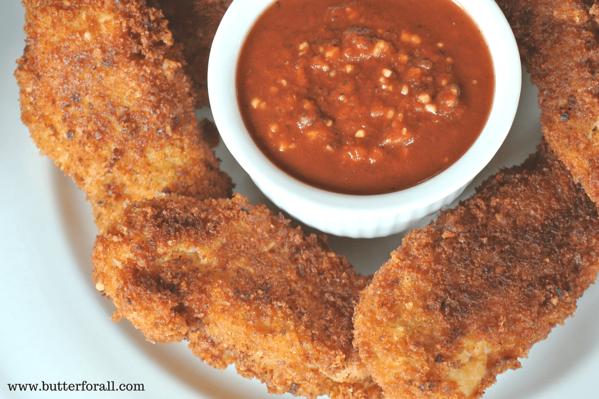 Freshly fired, golden brown and crispy Parmesan and sourdough crusted chicken strips.