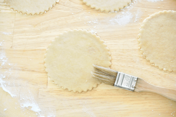 Each mini pie crust is brushed with water to help them seal.