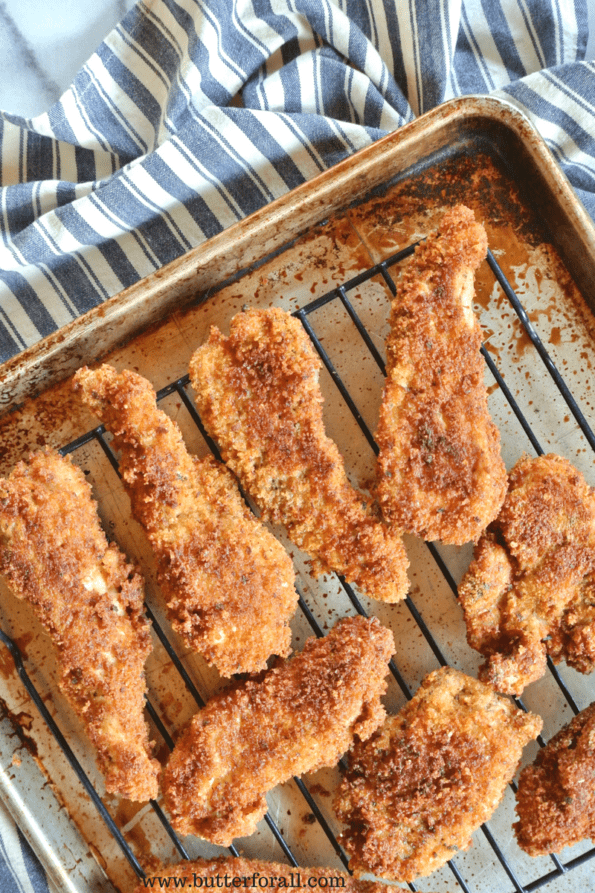 A tray of crispy chicken strips coated in real sourdough bread crumbs and Parmesan cheese.