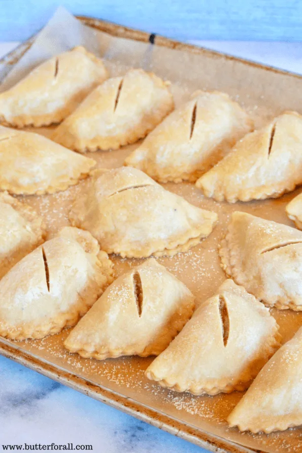 The pies are placed on a parchment lined baking sheet.