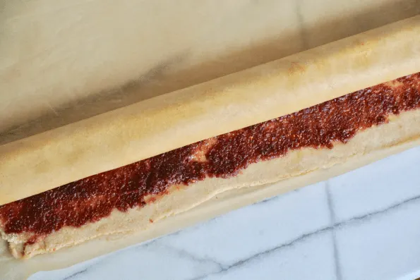 Roll the sourdough pastry into a tight cylinder from the top down.