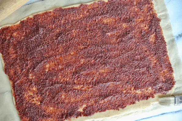 Spreading the cranberry filling over the sourdough pastry.