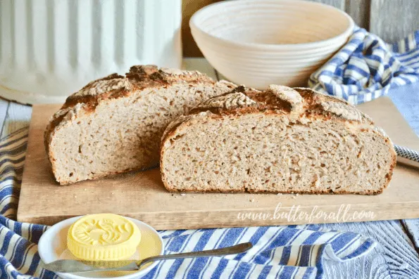 A soft and chewy loaf of sourdough bread cut in half to reveal the sweet whole grain crumb.