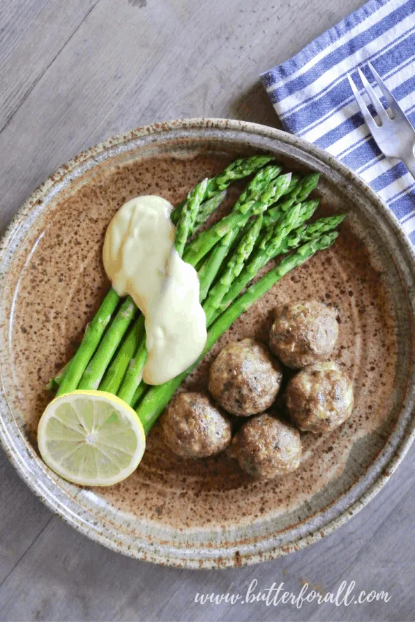 A plate of meatballs with asparagus.